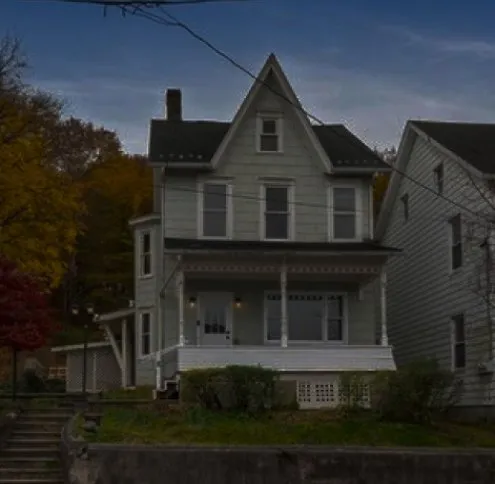Slatington service area: a white clapboard Victorian house with a covered front porch, autumn trees behind