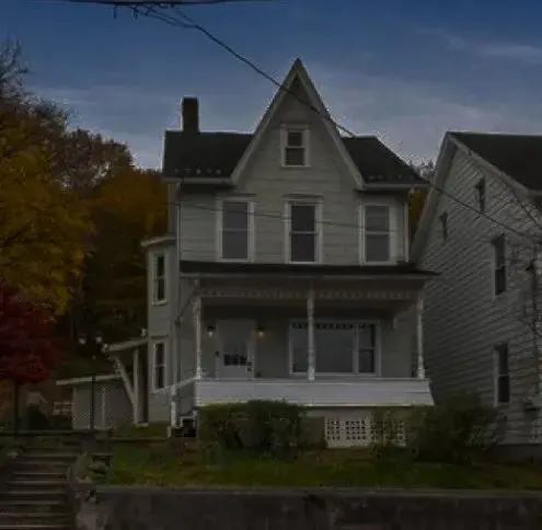 Slatington service area: a white clapboard Victorian house with a covered front porch, autumn trees behind