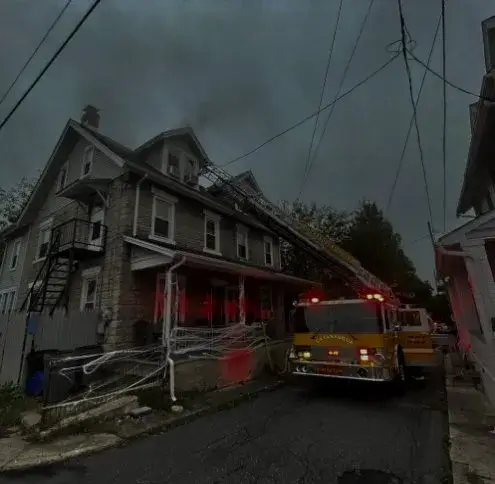 Catasauqua service area: a fire engine lettered Catasauqua with its ladder raised to the roof of a smoking house