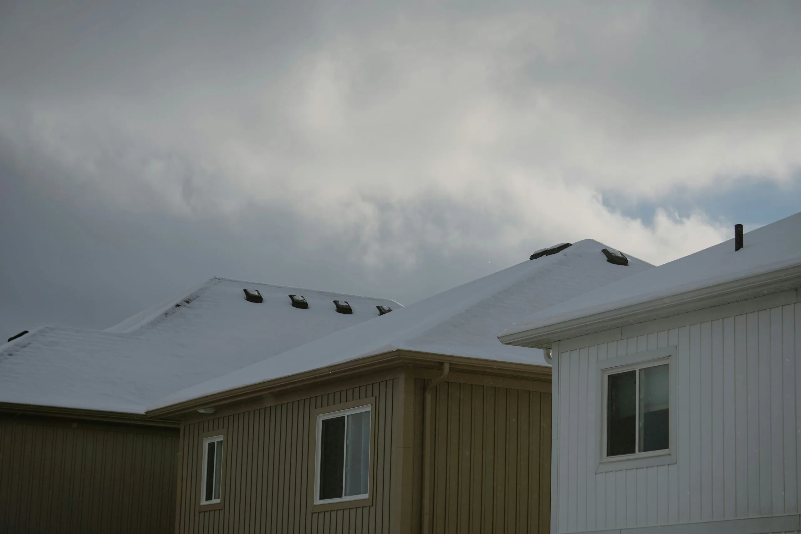 Winter roof maintenance tips Allentown homeowner clearing snow from a roof