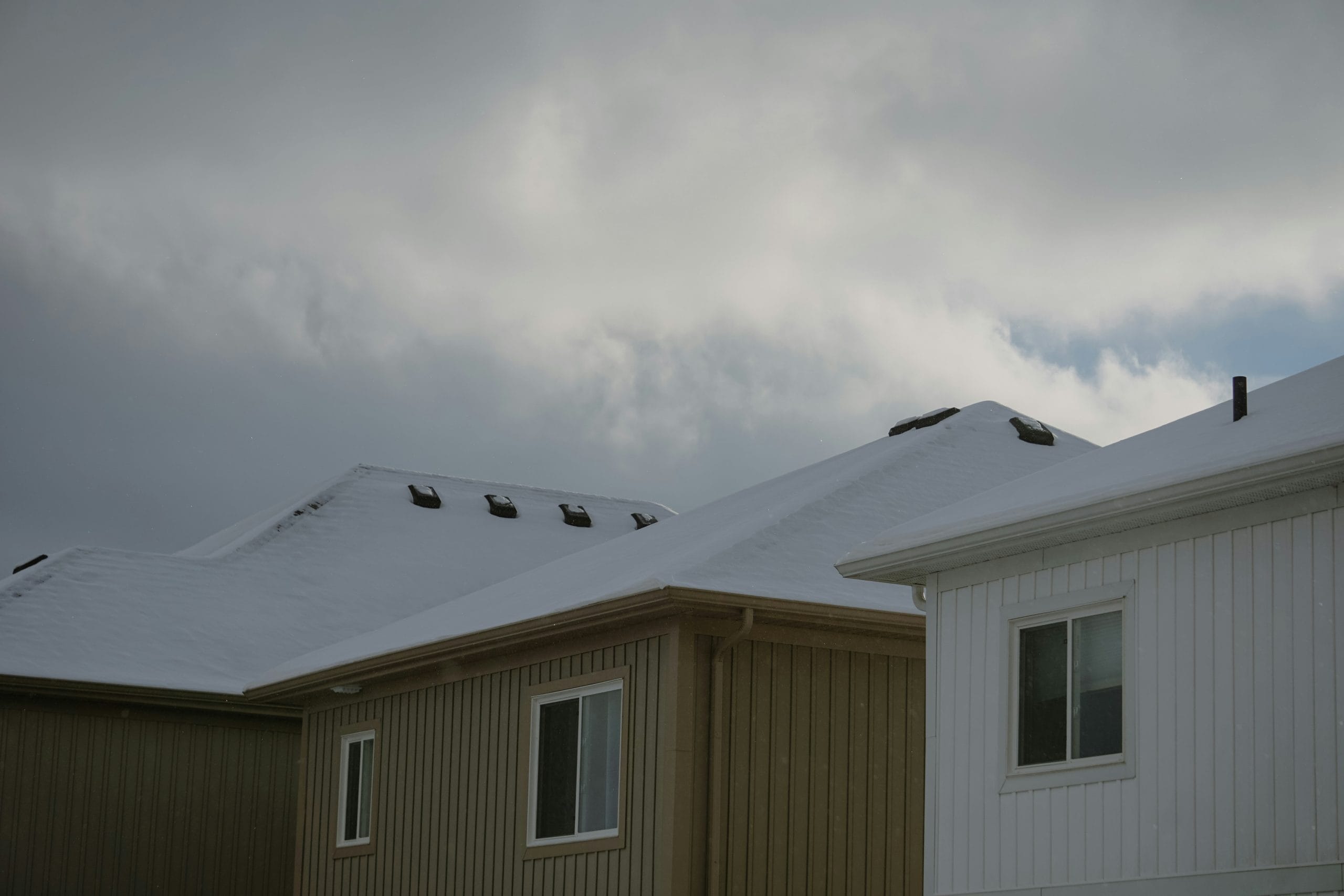Winter roof maintenance tips Allentown homeowner clearing snow from a roof